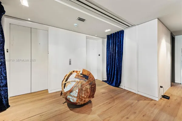 a view of a room with wooden floor and cabinet