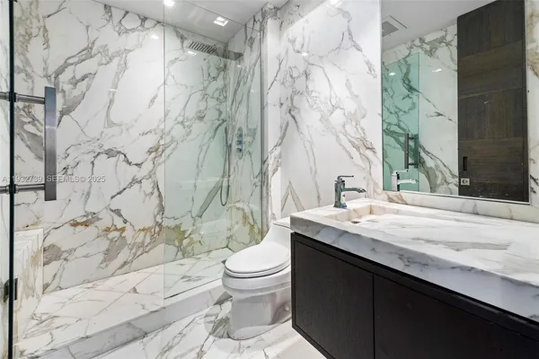 a bathroom with a granite countertop sink toilet and shower