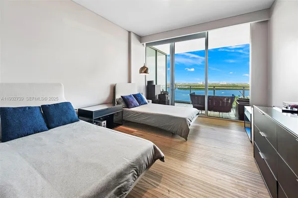 a bedroom with two beds and a large window