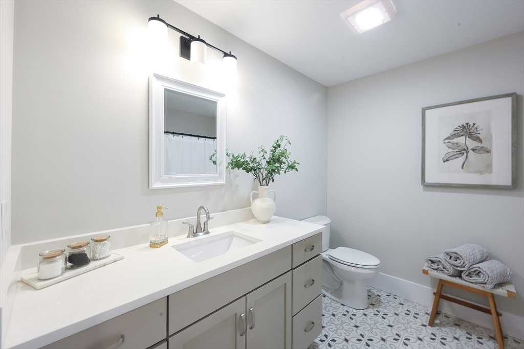 55 Thomas Mann Circle, Unit 32 Norfolk, MA 02056 - Photo 15 of 31 a bathroom with a sink toilet and a mirror