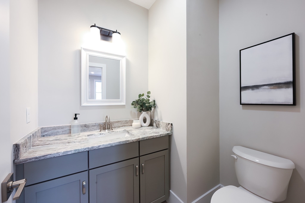 55 Thomas Mann Circle, Unit 32 Norfolk, MA 02056 - Photo 16 of 31 a bathroom with a toilet sink and mirror