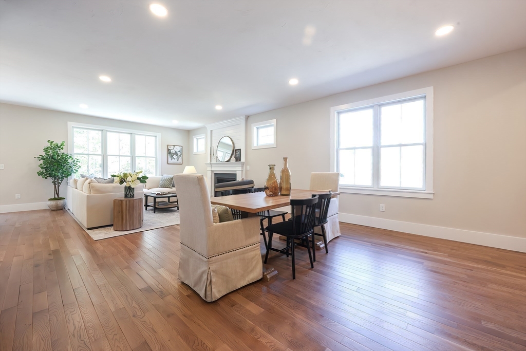 55 Thomas Mann Circle, Unit 32 Norfolk, MA 02056 - Photo 22 of 31 a living room with furniture dining table a large window and a potted plant