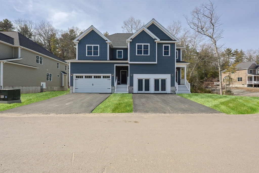55 Thomas Mann Circle, Unit 32 Norfolk, MA 02056 - Photo 24 of 31 a front view of a house with a yard and garage