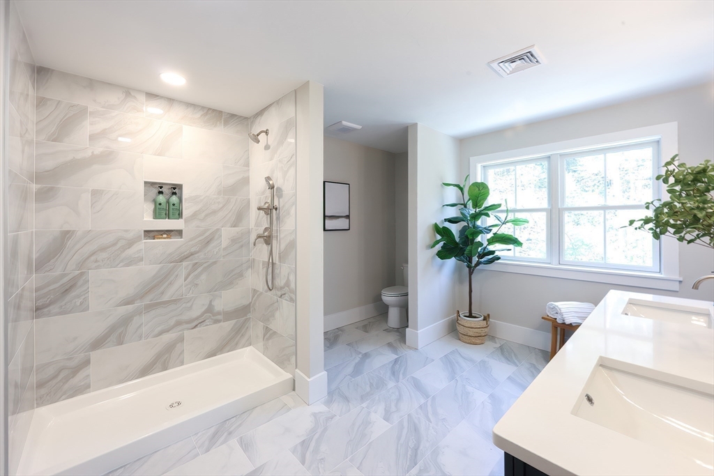 55 Thomas Mann Circle, Unit 32 Norfolk, MA 02056 - Photo 30 of 31 a view of a bathroom with a tub and shower