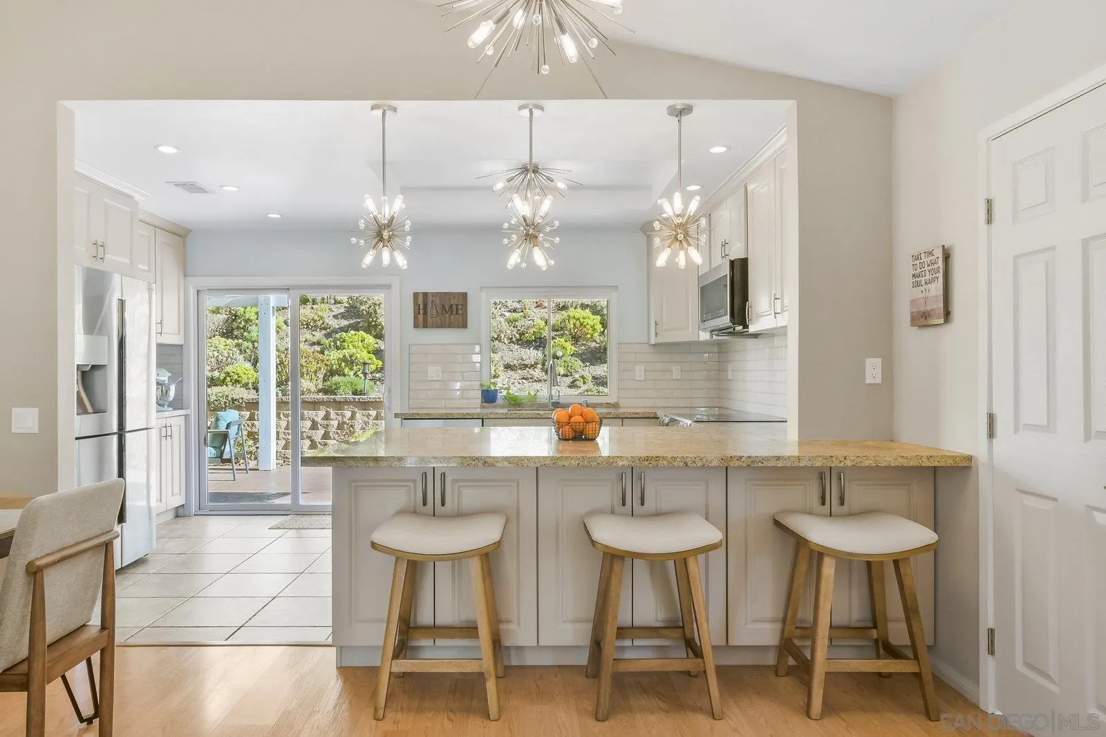 12061 Rue Des Amis San Diego, CA 92131 - Photo 11 of 33 a kitchen with stainless steel appliances a table and chairs in it