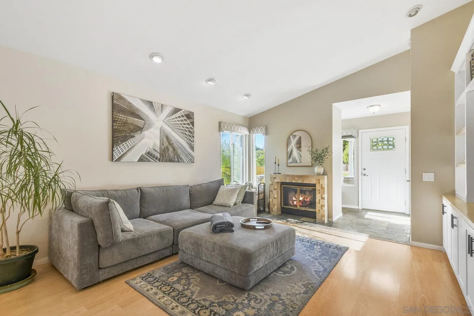 12061 Rue Des Amis San Diego, CA 92131 - Photo 7 of 33 a living room with furniture a fireplace and a potted plant