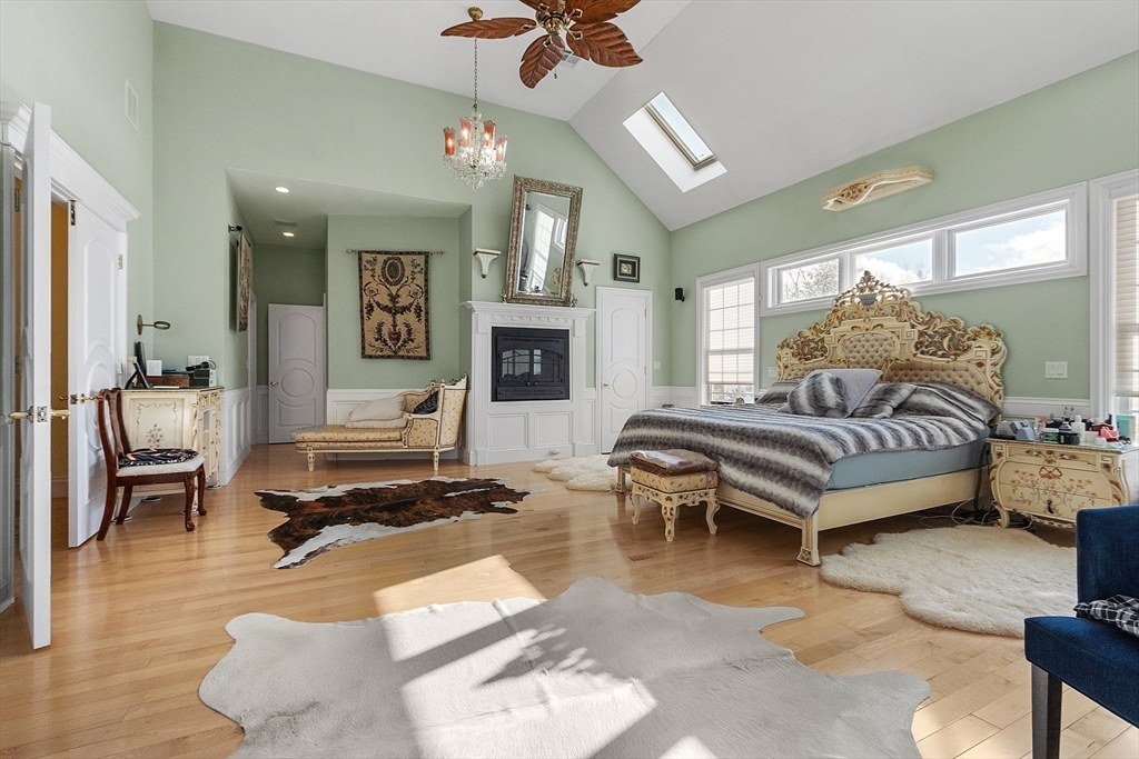 30 Bridle Path Shrewsbury, MA 01545 - Photo 23 of 41 a spacious bedroom with a bed a couch and a chandelier