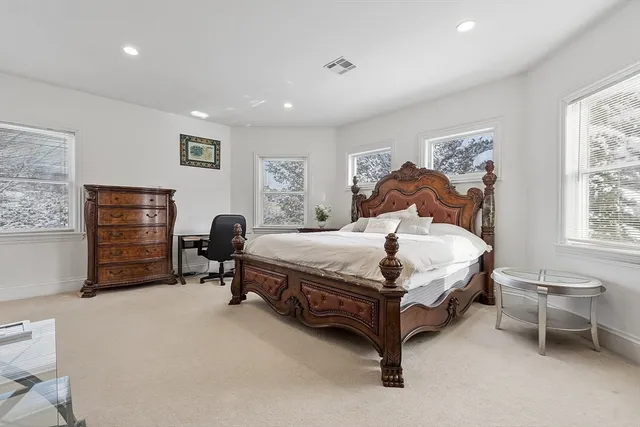 a spacious bedroom with a bed and a window