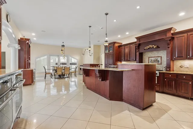 a kitchen with stainless steel appliances granite countertop a refrigerator a sink a stove and a cabinets