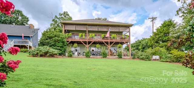 a view of a house with a yard and potted plants