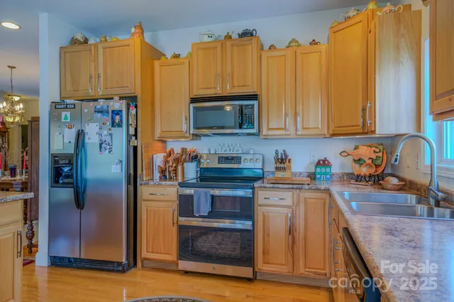a kitchen with stainless steel appliances granite countertop a refrigerator a stove and a sink