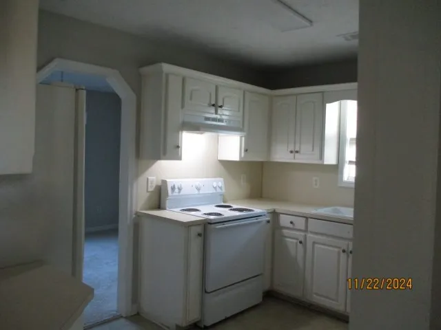 a kitchen with cabinets appliances a sink and a window