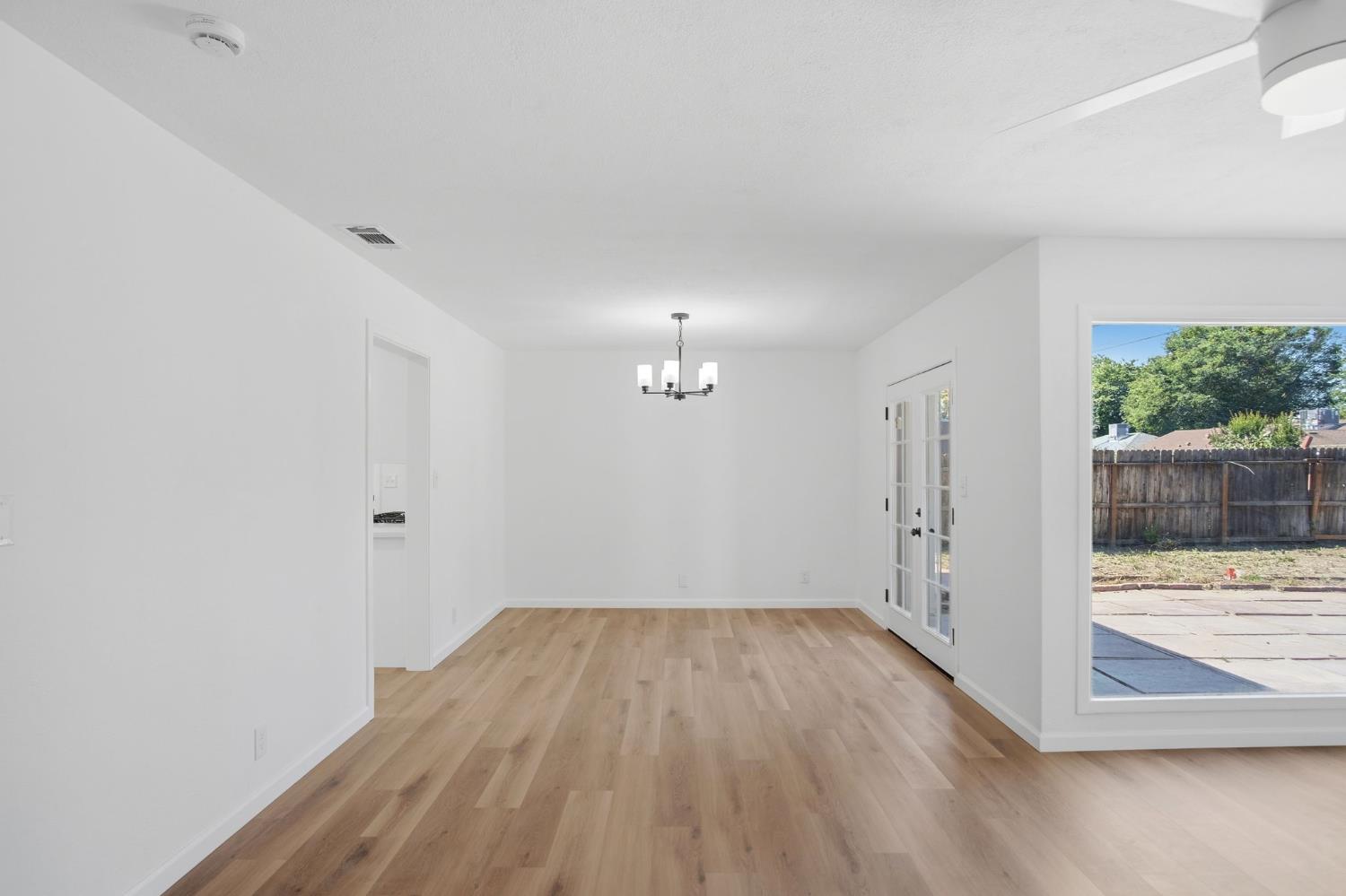 1451 Kent Way Modesto, CA 95355 - Photo 8 of 37 an empty room with wooden floor and windows
