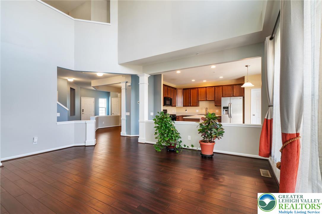 8455 Starling Road Breinigsville, PA 18031 - Photo 24 of 24 An open floorplan seamlessly connects the well-lit living area with rich hardwood flooring to a modern kitchen.