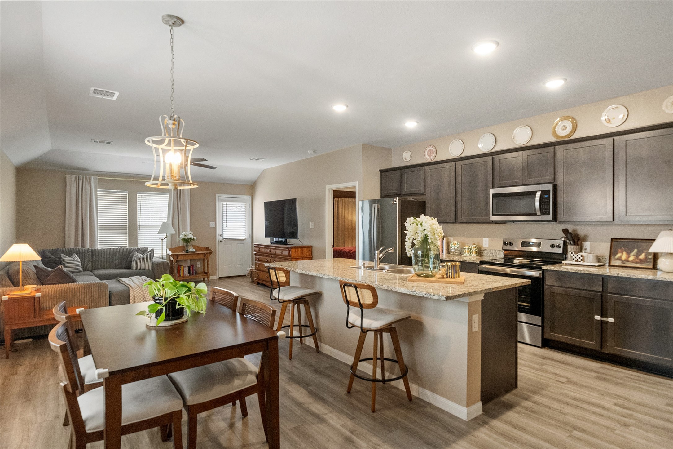 26431 Pin Oak Drive Hempstead, TX 77445 - Photo 2 of 31 a kitchen with stainless steel appliances kitchen island granite countertop a dining table chairs stove refrigerator and cabinets