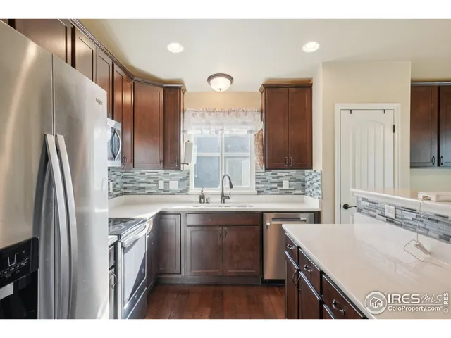 a kitchen with a sink refrigerator and cabinets