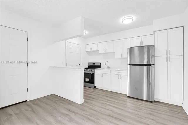 a kitchen with a refrigerator a sink and a microwave