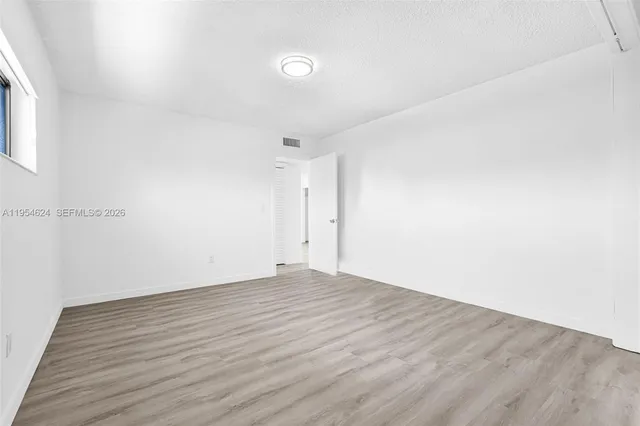 a view of a kitchen with a refrigerator and wooden floor