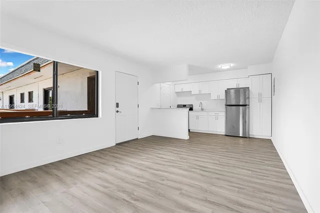 a kitchen with a refrigerator and a stove top oven