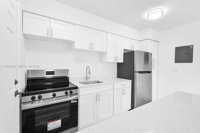 a kitchen with appliances a sink a stove and cabinets