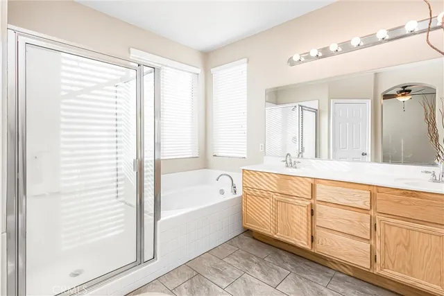 a bathroom with a bathtub a double vanity sink and windows