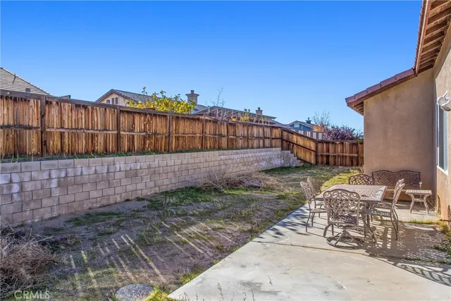 a view of a chair and table in the backyard