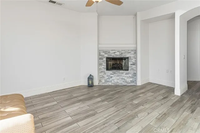 a view of empty room with wooden floor and fireplace