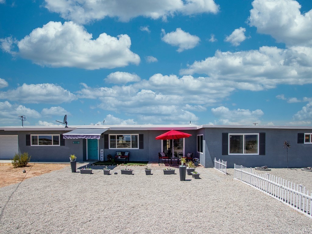 a view of a house with wooden fence and a tree