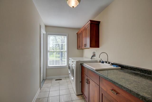 3456 Lake Road Woodlawn, TN 37191 - Photo 12 of 20 You will enjoy doing laundry in this large laundry room off hall which features front load washer and dryer included in sale as well as large soaking sink and plenty of cabinets and counter space for folding-also has large storage closet-stairs to le