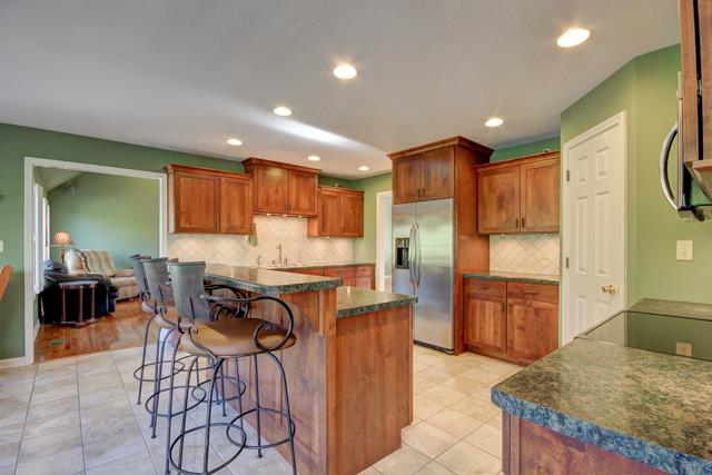 wow look at this kitchen featuring custom cabinets-water purifier system on sink, stainless appliances, pantry, tile flooring and chefs island