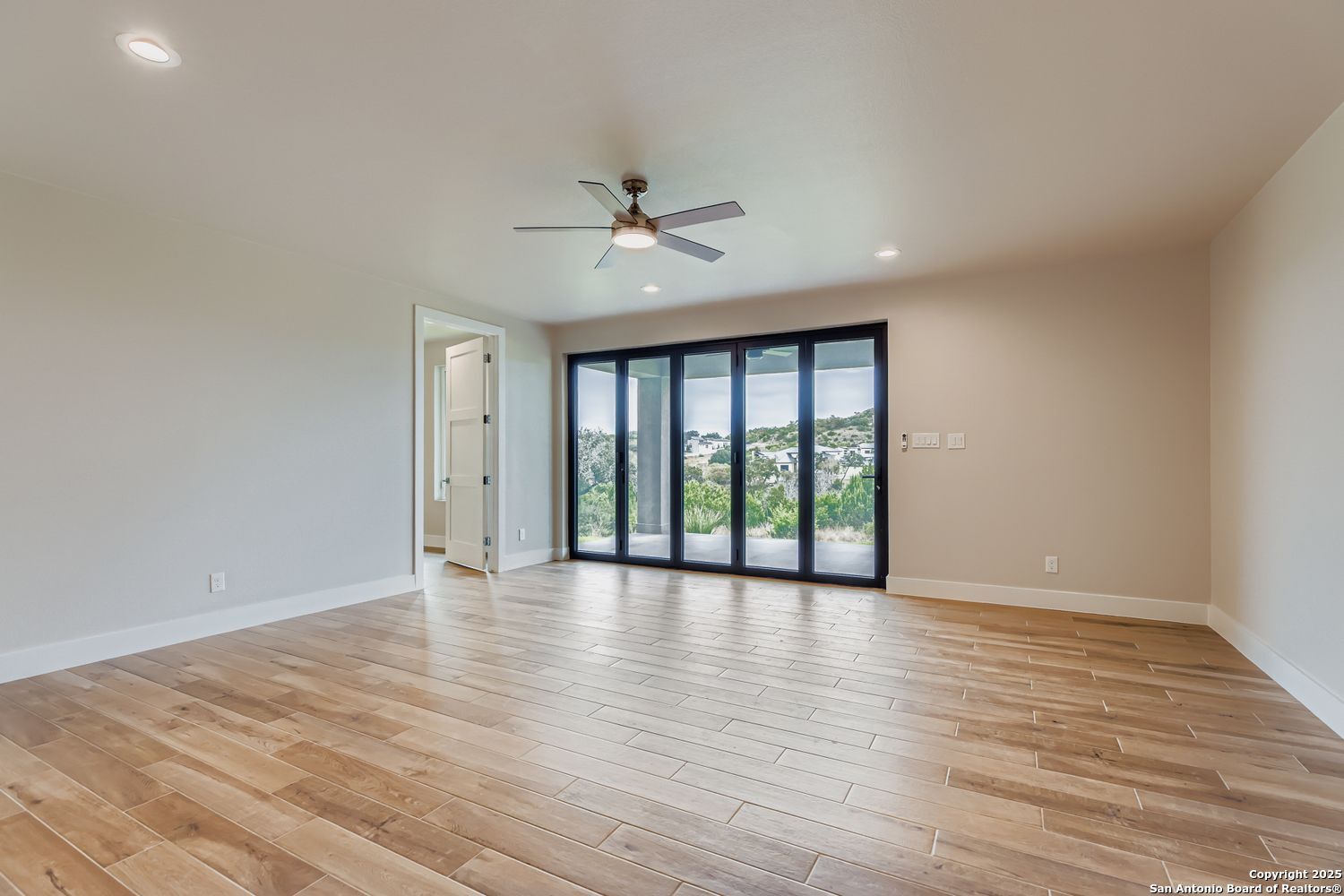 23202 Walker Ridge San Antonio, TX 78255 - Photo 27 of 44 a view of an empty room with a window and wooden floor