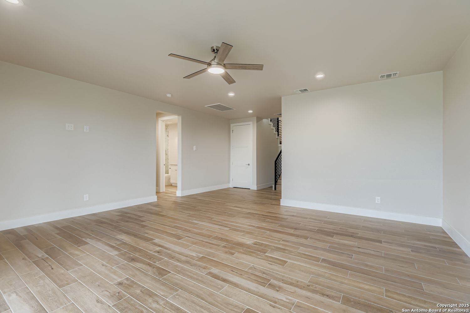 23202 Walker Ridge San Antonio, TX 78255 - Photo 28 of 44 a view of an empty room with wooden floor and a ceiling fan