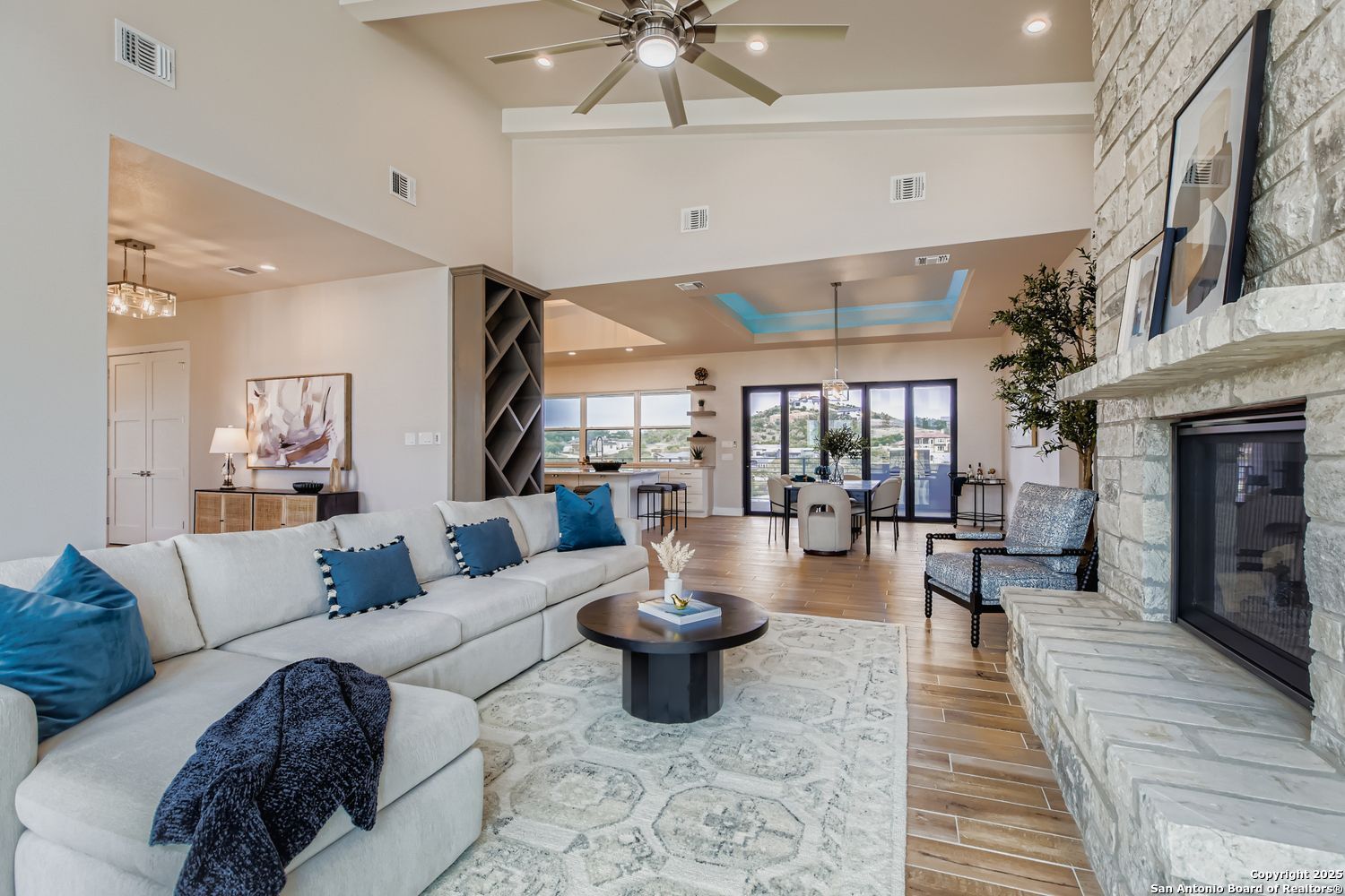 23202 Walker Ridge San Antonio, TX 78255 - Photo 5 of 44 a living room with furniture a fireplace and a chandelier