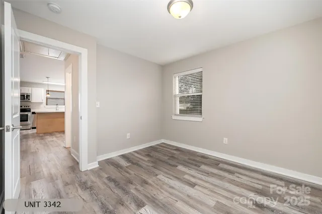 a view of a room with wooden floor and a large window