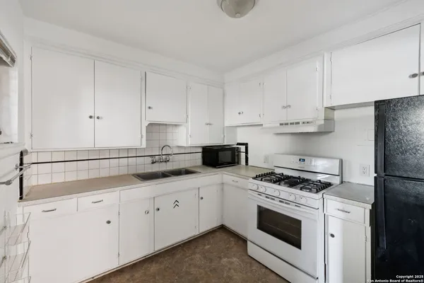 a kitchen with granite countertop white cabinets and white appliances