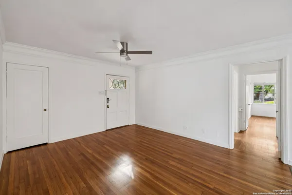 a view of empty room with wooden floor