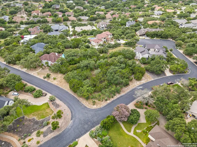 an aerial view of a house with a yard and lake view