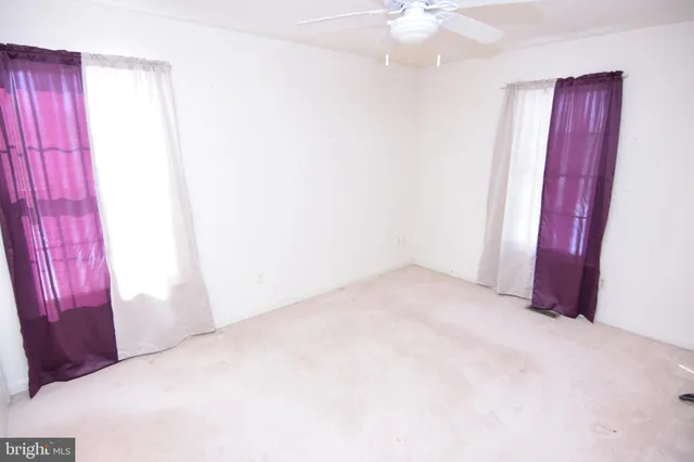 an empty room with a chandelier fan