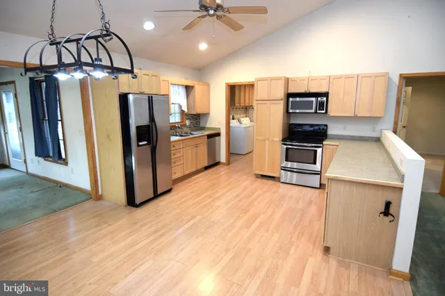 a kitchen with stainless steel appliances a refrigerator and a stove top oven