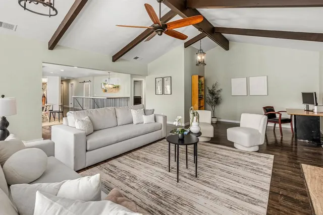 a spacious bedroom with a bed a table and windows