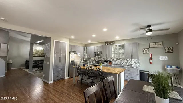a kitchen with stainless steel appliances a dining table chairs and wooden floor