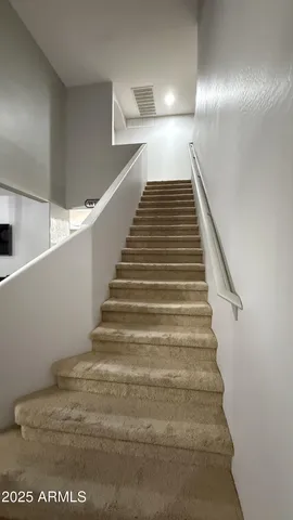 a view of a livingroom with wooden floor and staircase