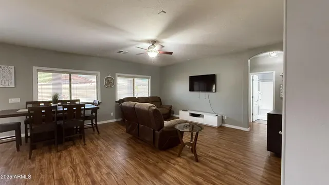 a living room with furniture a dining table and a wooden floor