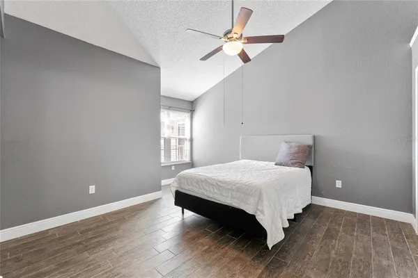 a bedroom with a bed chandelier and a window
