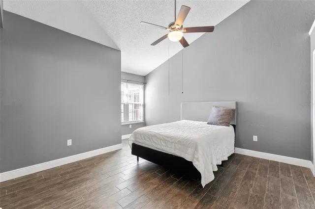 a bedroom with a bed chandelier and a window
