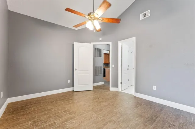 an empty room with closet and a ceiling fan