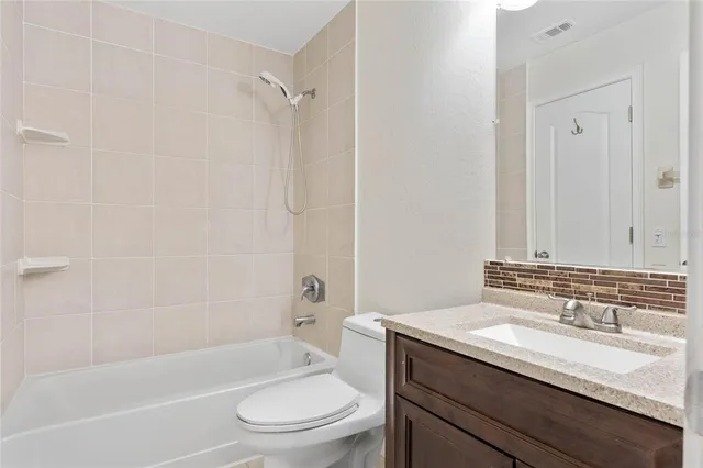 a bathroom with a granite countertop sink a toilet and shower