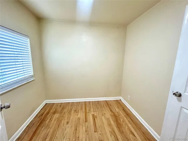 a view of a room with wooden floor and window