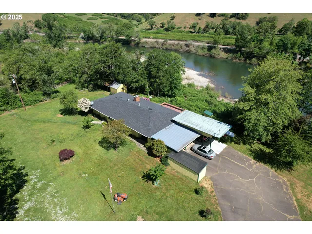 an aerial view of a house with garden space and lake view