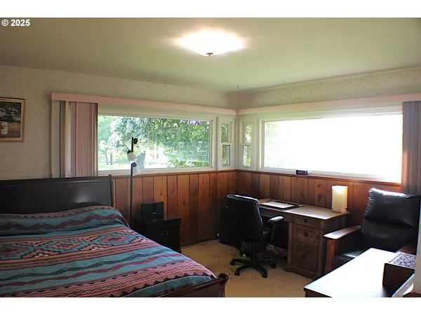 a bedroom with a bed and a painting on the wall